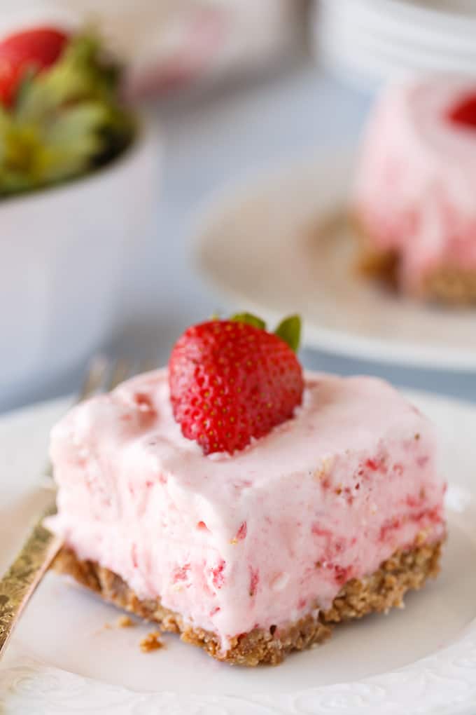 Frozen Strawberry Fluff - A sweet summer frozen delight! A buttery cookie crust is topped by a creamy, cold strawberry layer of yum.