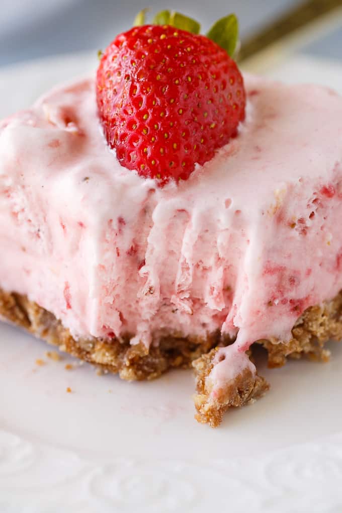 Frozen Strawberry Fluff - A sweet summer frozen delight! A buttery cookie crust is topped by a creamy, cold strawberry layer of yum.