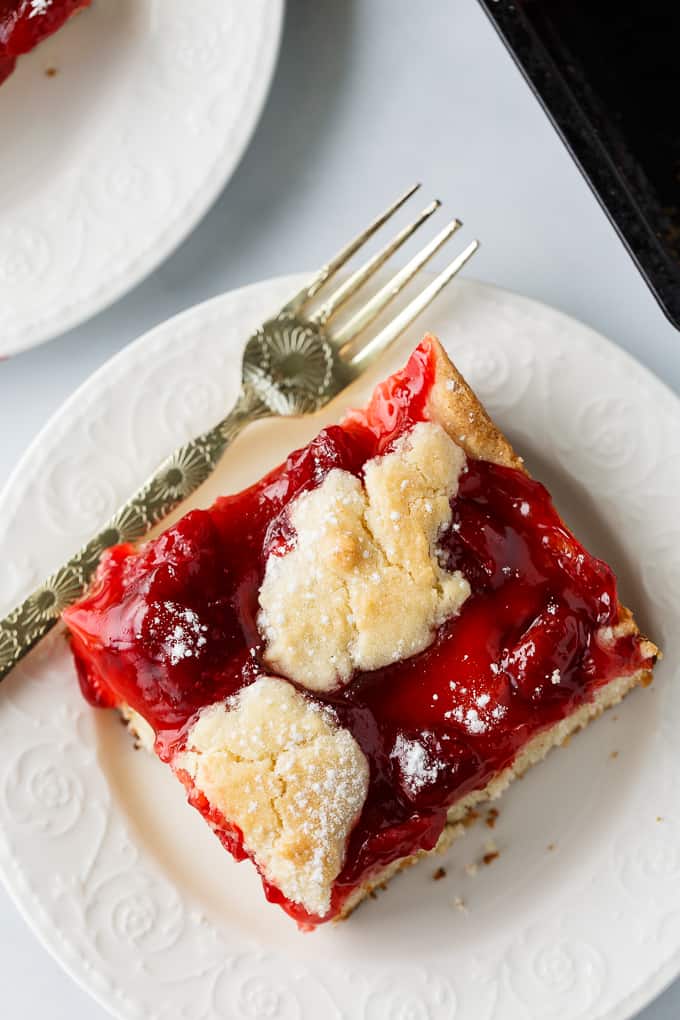 Quick Slice Cake - A simple fruit topped cake recipe made on a cookie sheet. The cake is sweet and dense and you can use any fruit pie filling you love!