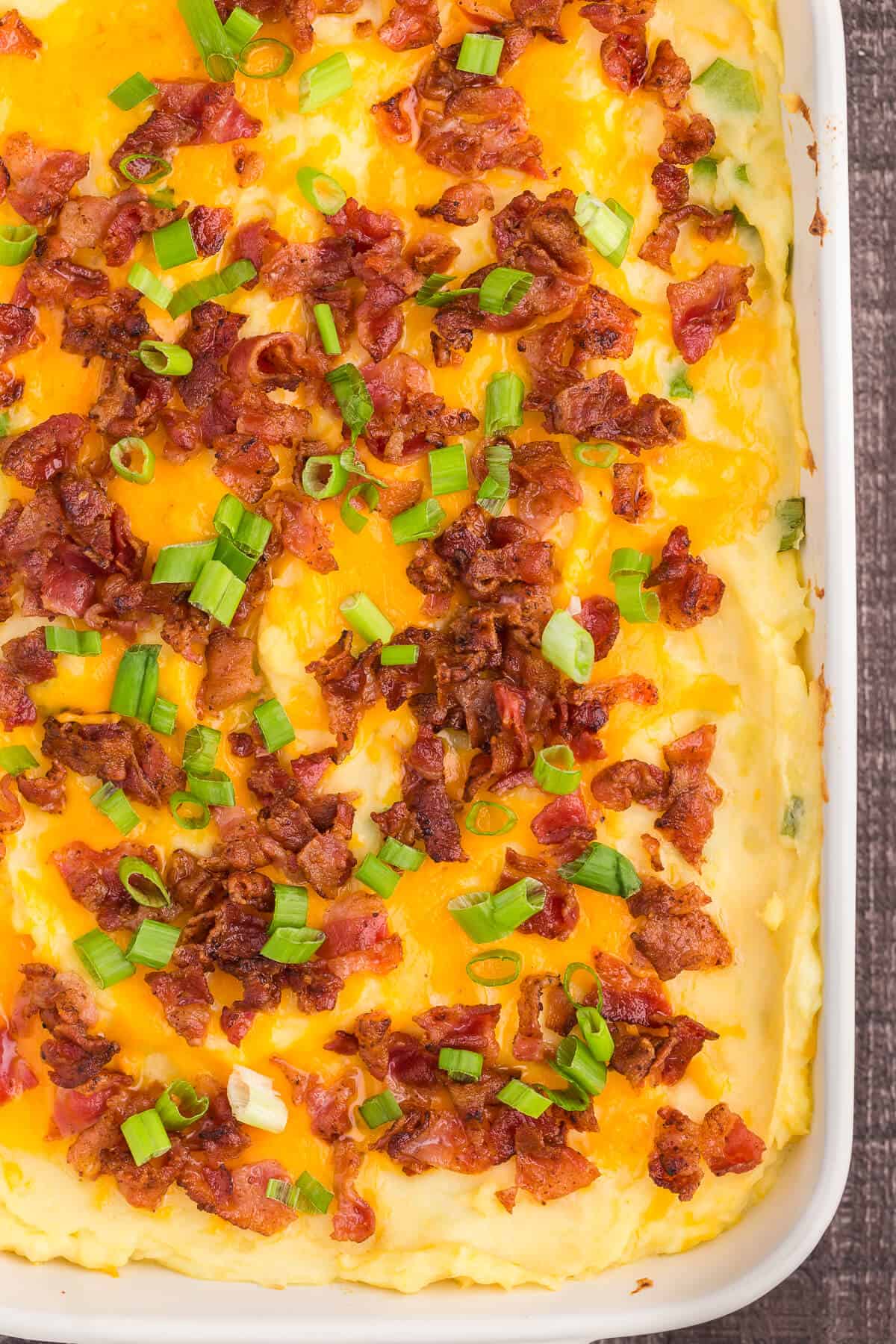 Loaded Mashed Potatoes - The ultimate comfort food side dish recipe. This homemade casserole is extra indulgent with loads of cheese, bacon and sour cream.