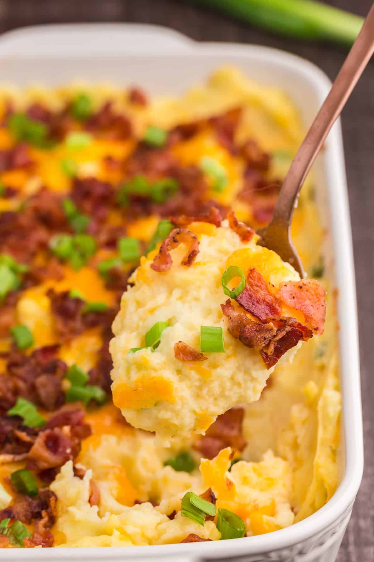 Loaded Mashed Potatoes - The ultimate comfort food side dish recipe. This homemade casserole is extra indulgent with loads of cheese, bacon and sour cream.