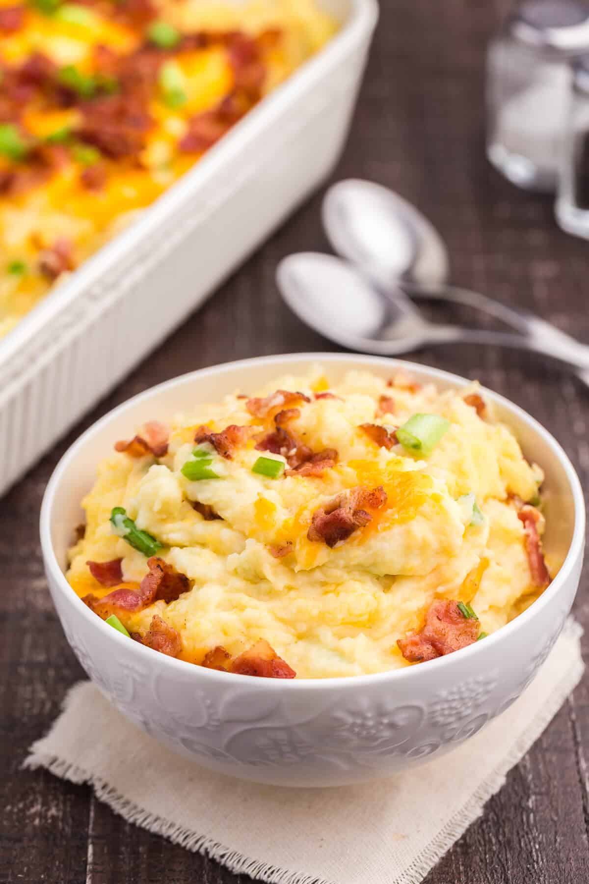 Loaded Mashed Potatoes - The ultimate comfort food side dish recipe. This homemade casserole is extra indulgent with loads of cheese, bacon and sour cream.