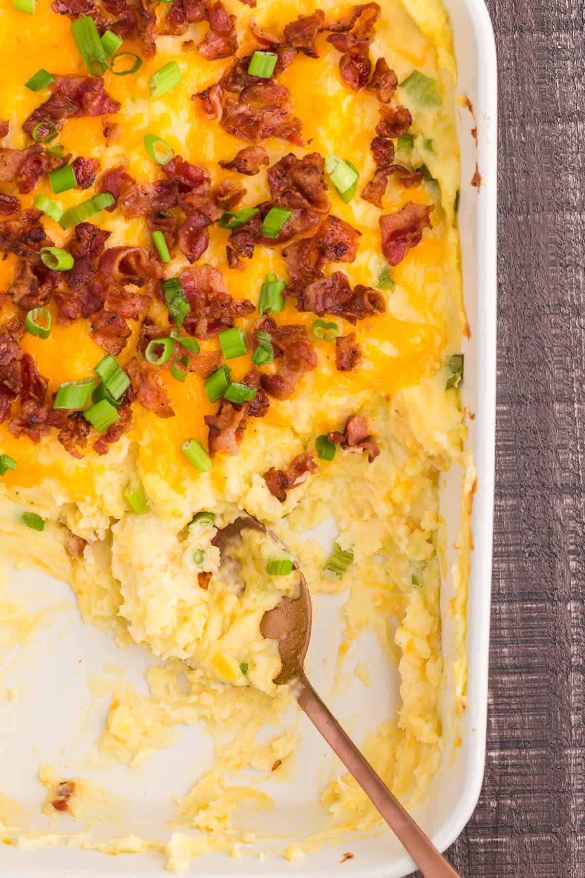 Loaded Mashed Potatoes - The ultimate comfort food side dish recipe. This homemade casserole is extra indulgent with loads of cheese, bacon and sour cream.