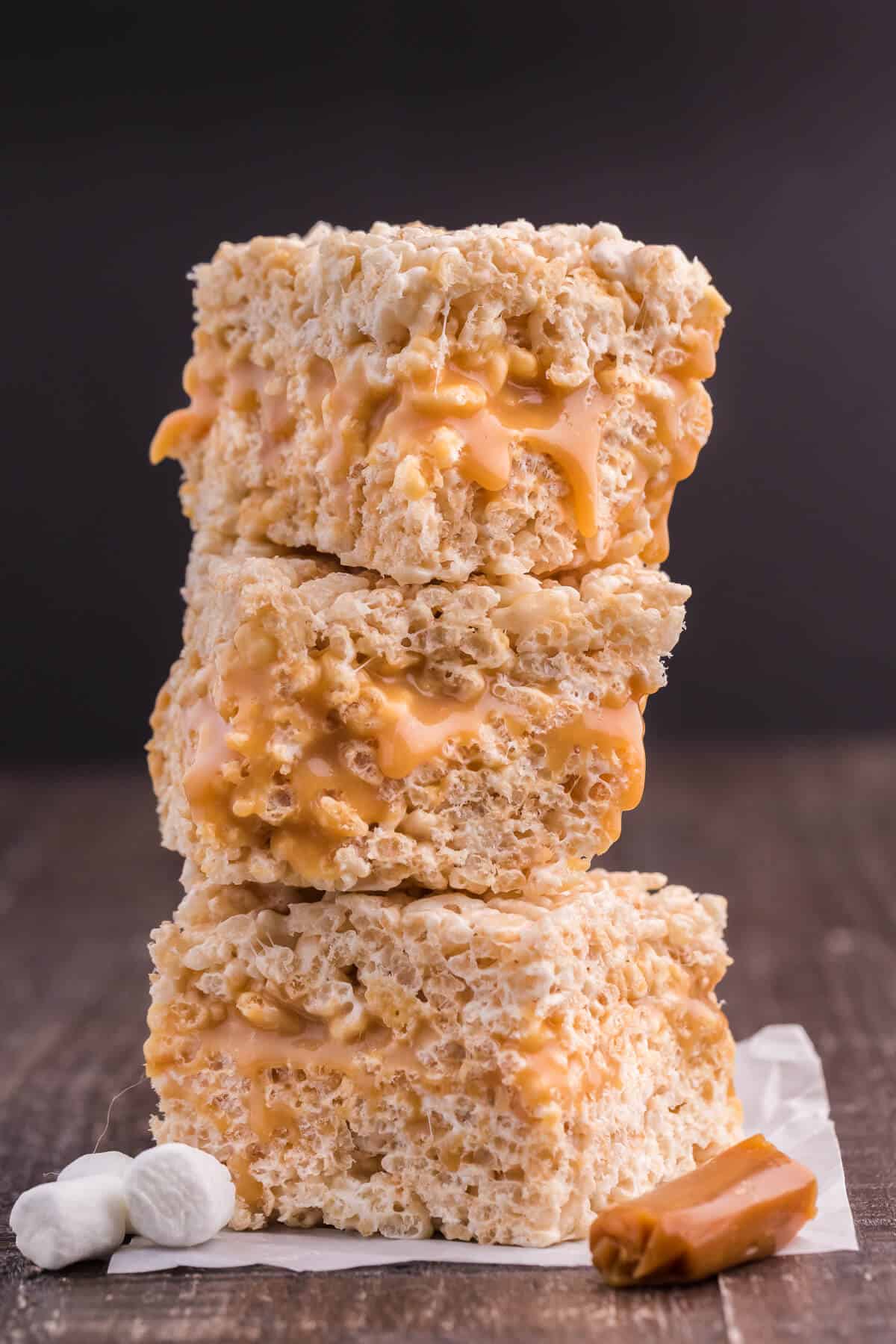 Caramel Rice Krispie Bars - Just the like the childhood classic recipe you remember, but so much better! Homemade caramel sauce is stuffed in between layers of Rice Krispie squares making this a go-to-dessert recipe everyone loves.