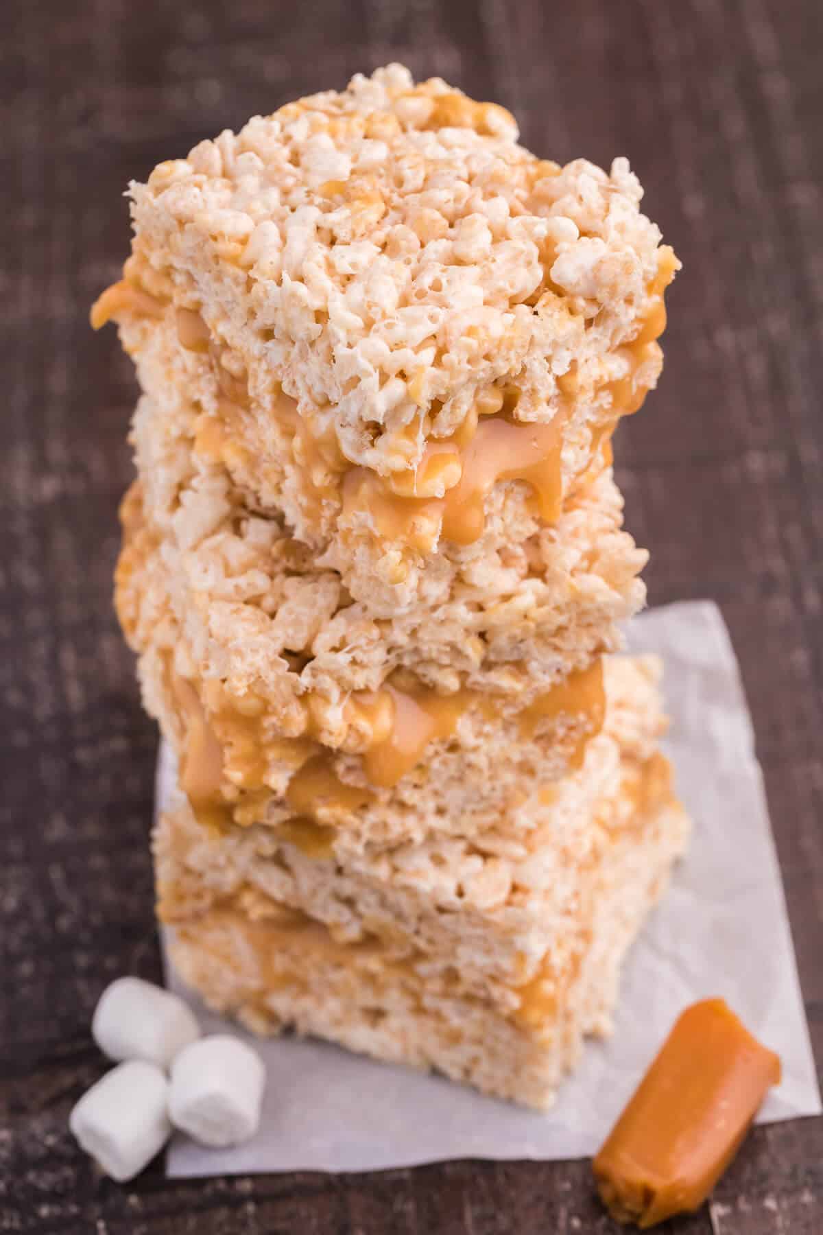 Caramel Rice Krispie Bars - Just the like the childhood classic recipe you remember, but so much better! Homemade caramel sauce is stuffed in between layers of Rice Krispie squares making this a go-to-dessert recipe everyone loves.