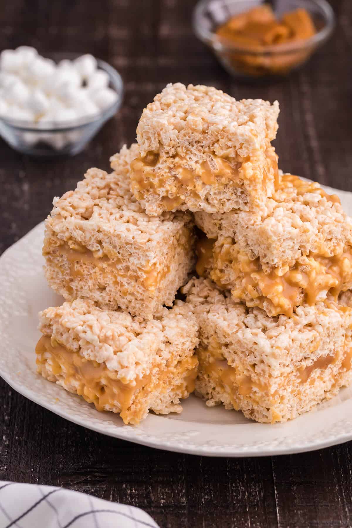 Caramel Rice Krispie Bars - Just the like the childhood classic recipe you remember, but so much better! Homemade caramel sauce is stuffed in between layers of Rice Krispie squares making this a go-to-dessert recipe everyone loves.