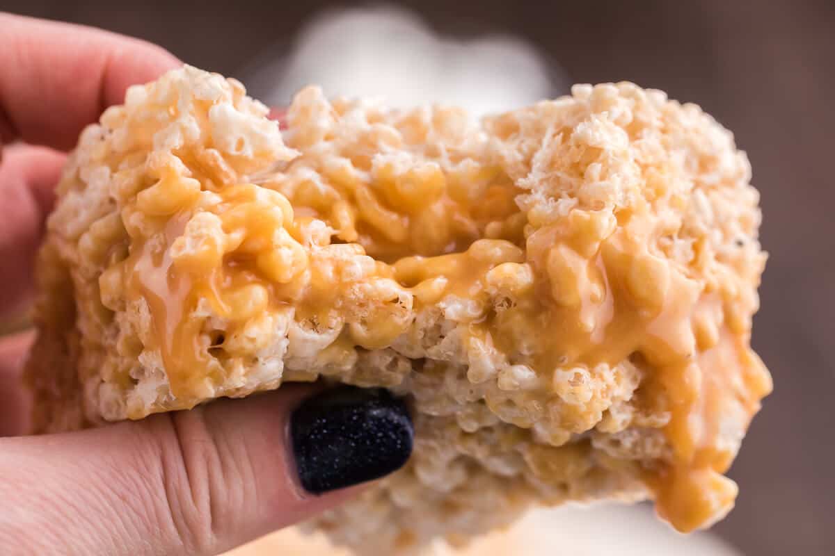 Caramel Rice Krispie Bars - Just the like the childhood classic recipe you remember, but so much better! Homemade caramel sauce is stuffed in between layers of Rice Krispie squares making this a go-to-dessert recipe everyone loves.