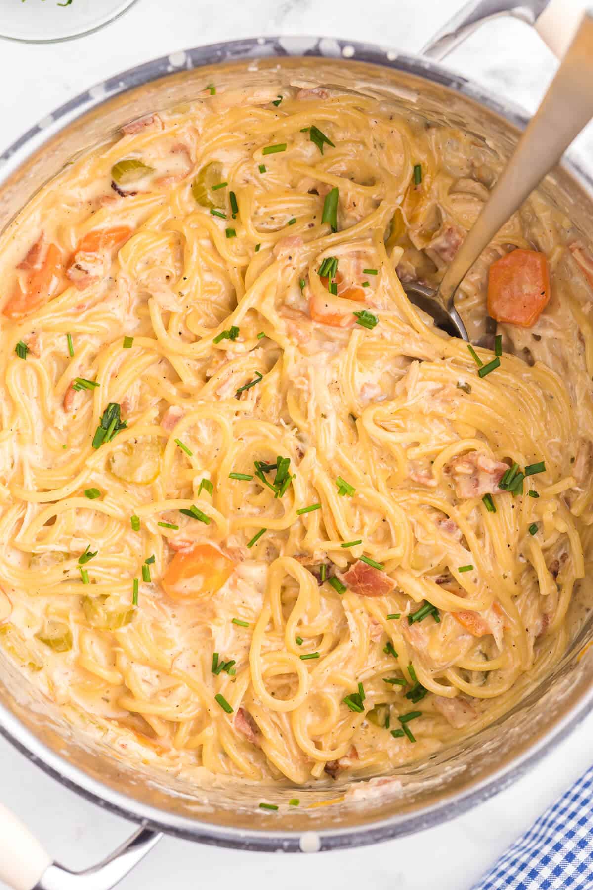 up close photo of crack chicken spaghetti in a pot with a serving spoon