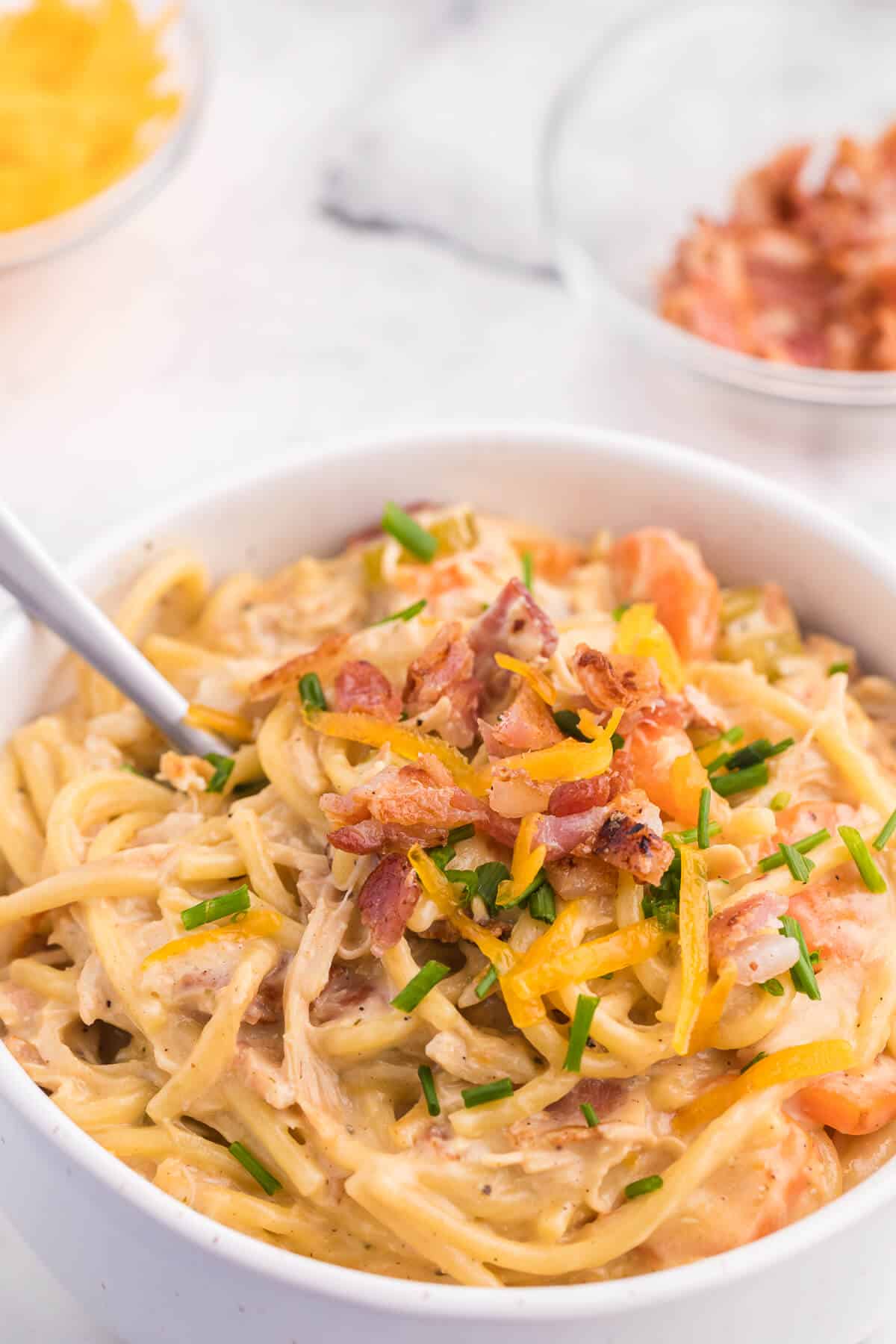 Crack Chicken Spaghetti Recipe - One bite and you'll be hooked! This easy and delicious dinner recipe is creamy, cheesy and addictive. It's loaded with chicken, bacon, veggies and spaghetti noodles in a flavorful cream cheese based sauce.