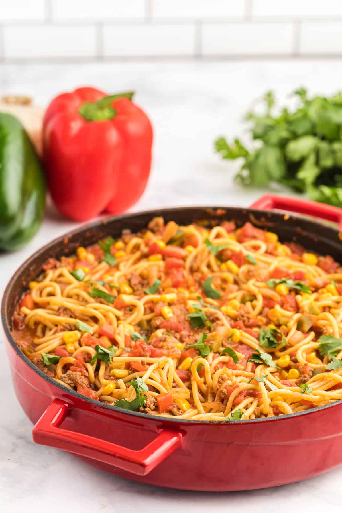 Mexican Spaghetti Recipe - This easy taco pasta recipe is filled with cheesy ground beef, taco seasoning, peppers, corn, tomatoes and noodles. It's simple to make with just the right amount of spice. The perfect family dinner recipe.