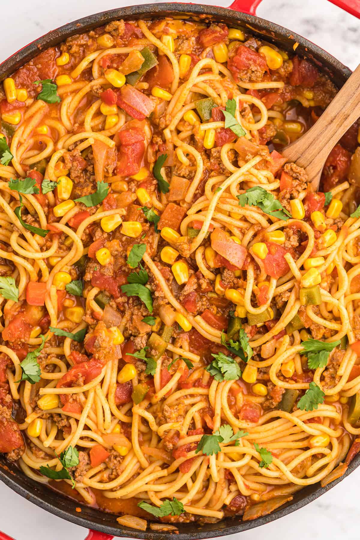 Mexican Spaghetti Recipe - This easy taco pasta recipe is filled with cheesy ground beef, taco seasoning, peppers, corn, tomatoes and noodles. It's simple to make with just the right amount of spice. The perfect family dinner recipe.