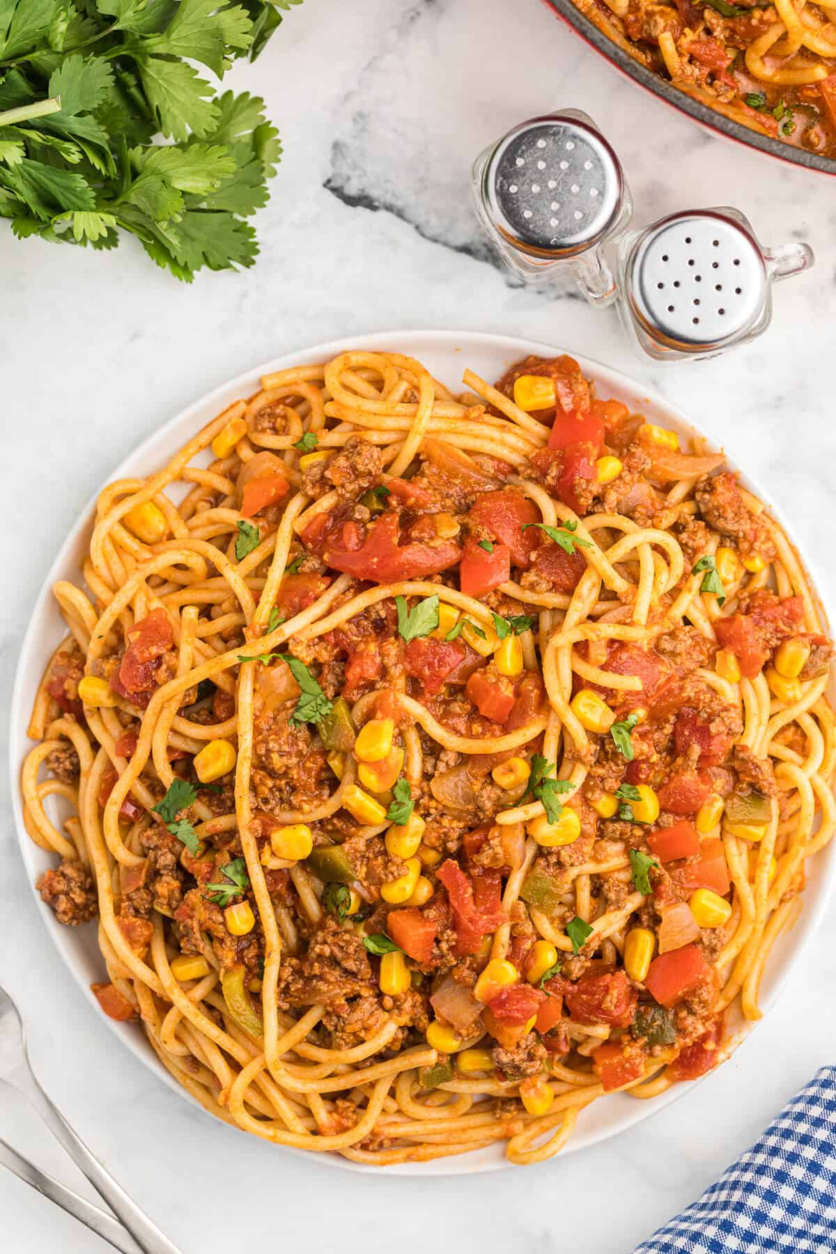 Mexican Spaghetti Recipe - This easy taco pasta recipe is filled with cheesy ground beef, taco seasoning, peppers, corn, tomatoes and noodles. It's simple to make with just the right amount of spice. The perfect family dinner recipe.