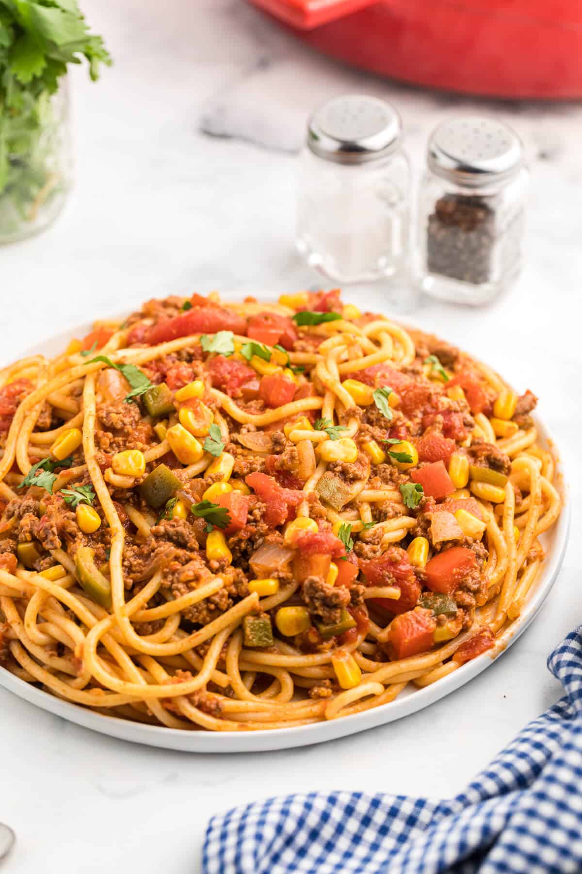 Mexican Spaghetti Recipe - This easy taco pasta recipe is filled with cheesy ground beef, taco seasoning, peppers, corn, tomatoes and noodles. It's simple to make with just the right amount of spice. The perfect family dinner recipe.