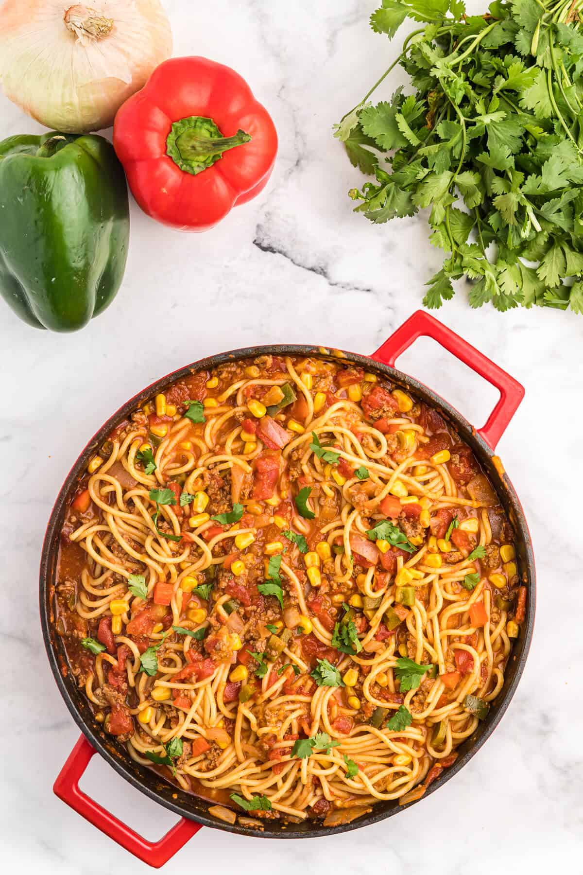 Mexican Spaghetti Recipe - This easy taco pasta recipe is filled with cheesy ground beef, taco seasoning, peppers, corn, tomatoes and noodles. It's simple to make with just the right amount of spice. The perfect family dinner recipe.