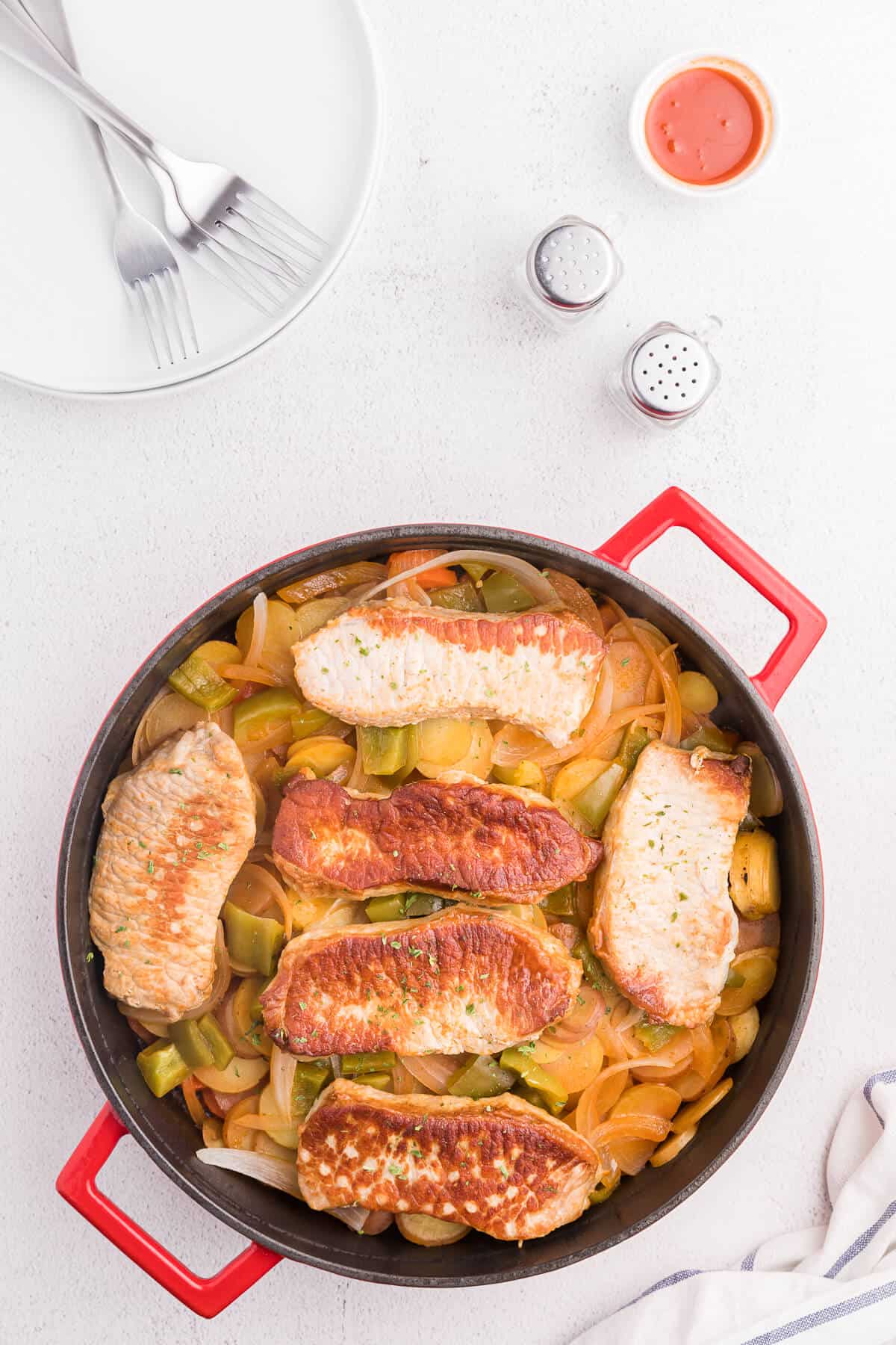 Pork Chop Skillet Dinner Recipe - A simple and delicious one-pan meal! Pork chops are cooked to perfection with potatoes, carrots, onions and green pepper in a tomato sauce with a kick.