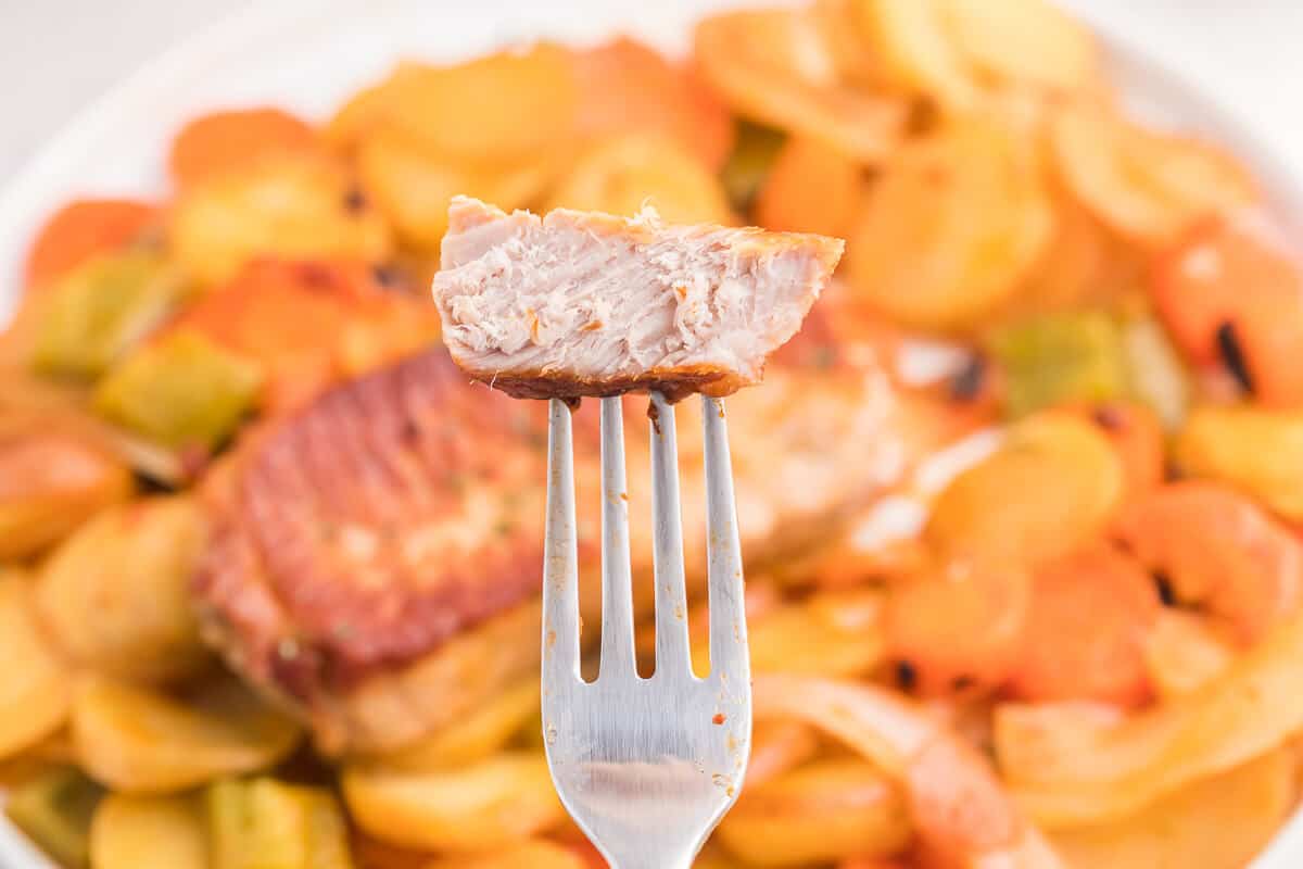 Pork Chop Skillet Dinner Recipe - A simple and delicious one-pan meal! Pork chops are cooked to perfection with potatoes, carrots, onions and green pepper in a tomato sauce with a kick.