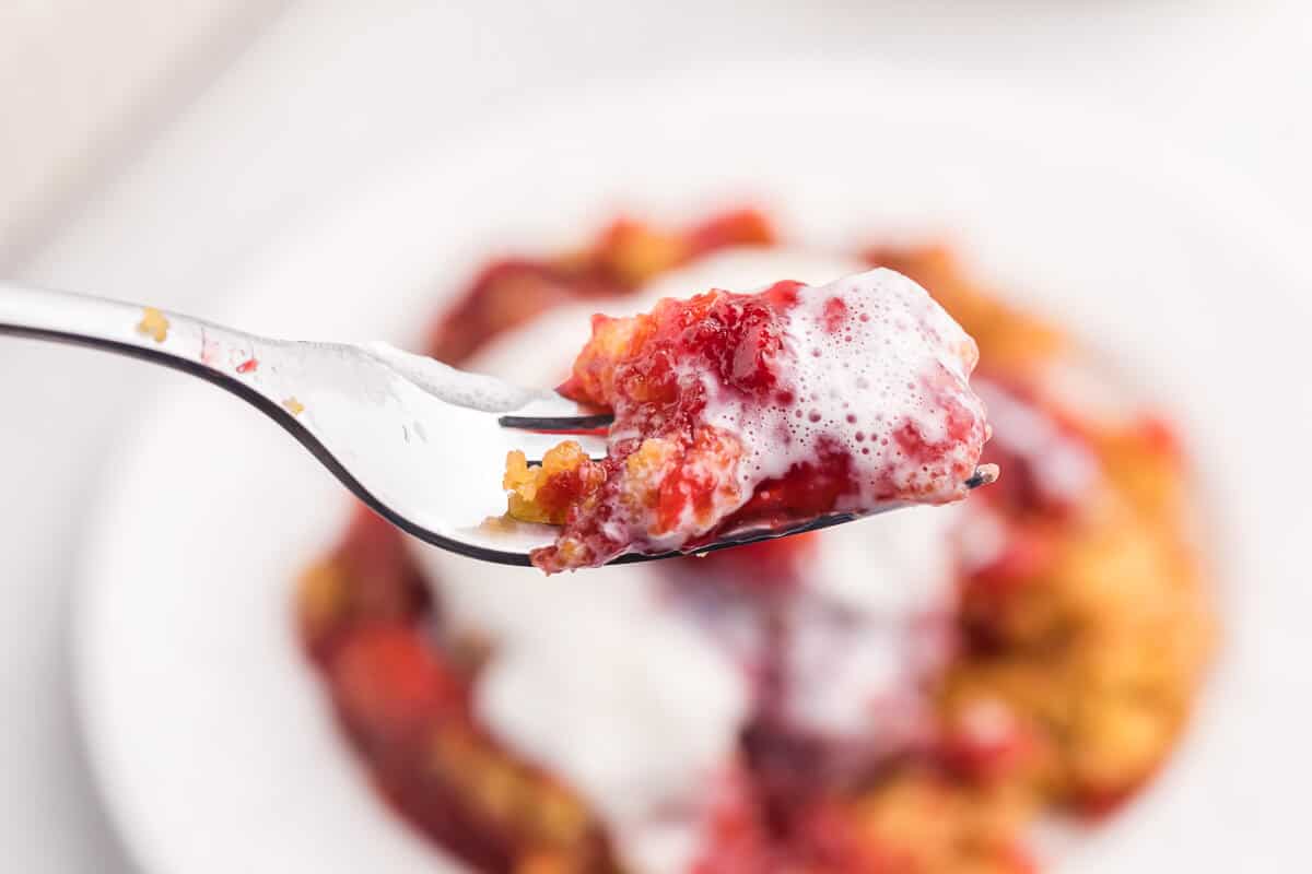 Strawberry Dump Cake Recipe - Only 4 ingredients in this simple sweet dessert! Cake mix and strawberry pie filling come together to make a luscious strawberry cake with little effort. One of the easiest dump cake recipes ever!