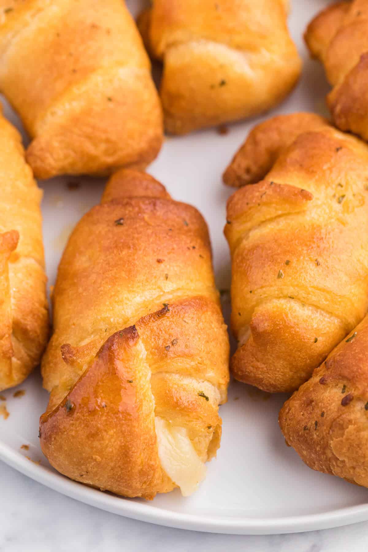 Air Fryer Garlic Cheese Stuffed Crescent Rolls Recipe - Use your air fryer to make this quick and easy snack or appetizer. Pillsbury crescent roll dough is brushed with garlic butter and wrapped around mozzarella cheese. Warning: they are addictive!