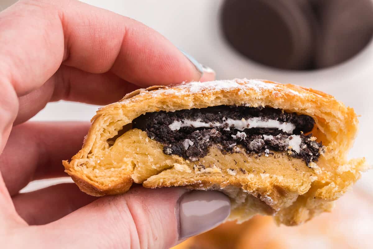 A hand holding the recipe cut in half.