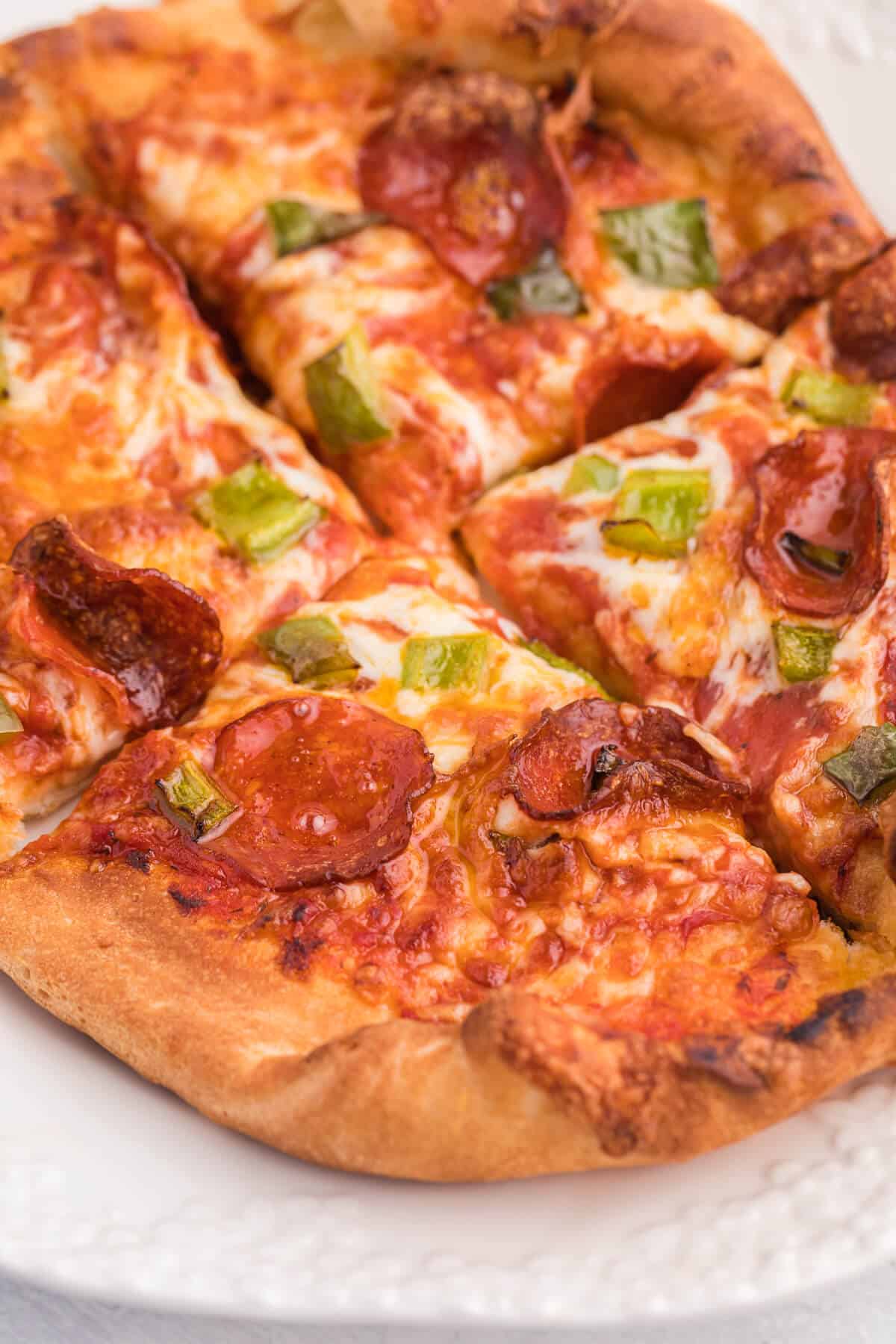 Air Fryer Pizza Recipe - Use premade pizza dough to make this better than delivery pizza right in your air fryer! This recipe makes two individual pizzas that are ready to eat in minutes.