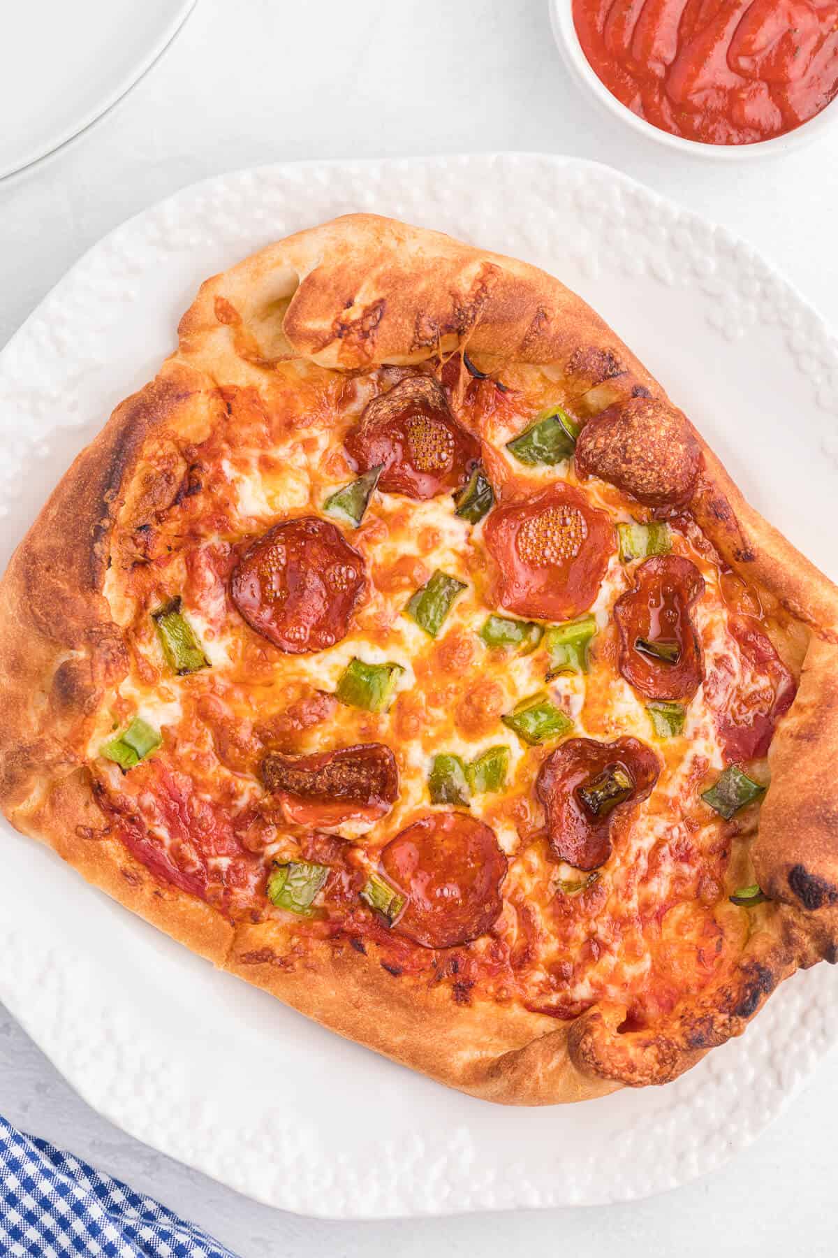 Air Fryer Pizza Recipe - Use premade pizza dough to make this better than delivery pizza right in your air fryer! This recipe makes two individual pizzas that are ready to eat in minutes.