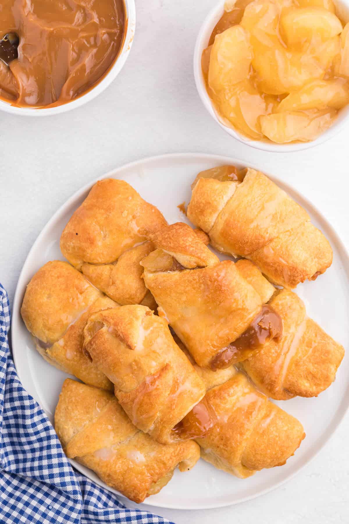 Caramel Apple Pie Crescents - The most simple apple dessert made in your air fryer in minutes! Buttery golden crescent roll pastry is wrapped around sweet apple pie filling and caramel with a sugar drizzle on top.