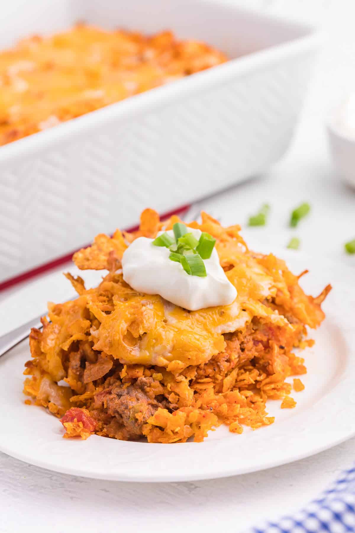 Doritos Casserole Recipe - Take Mexican night to a whole new level with this easy taco bake recipe. Made with ground beef, sour cream, spices and loads of cheese, it's zesty with hearty Tex Mex flavor. A yummy dinner recipe your family will love!