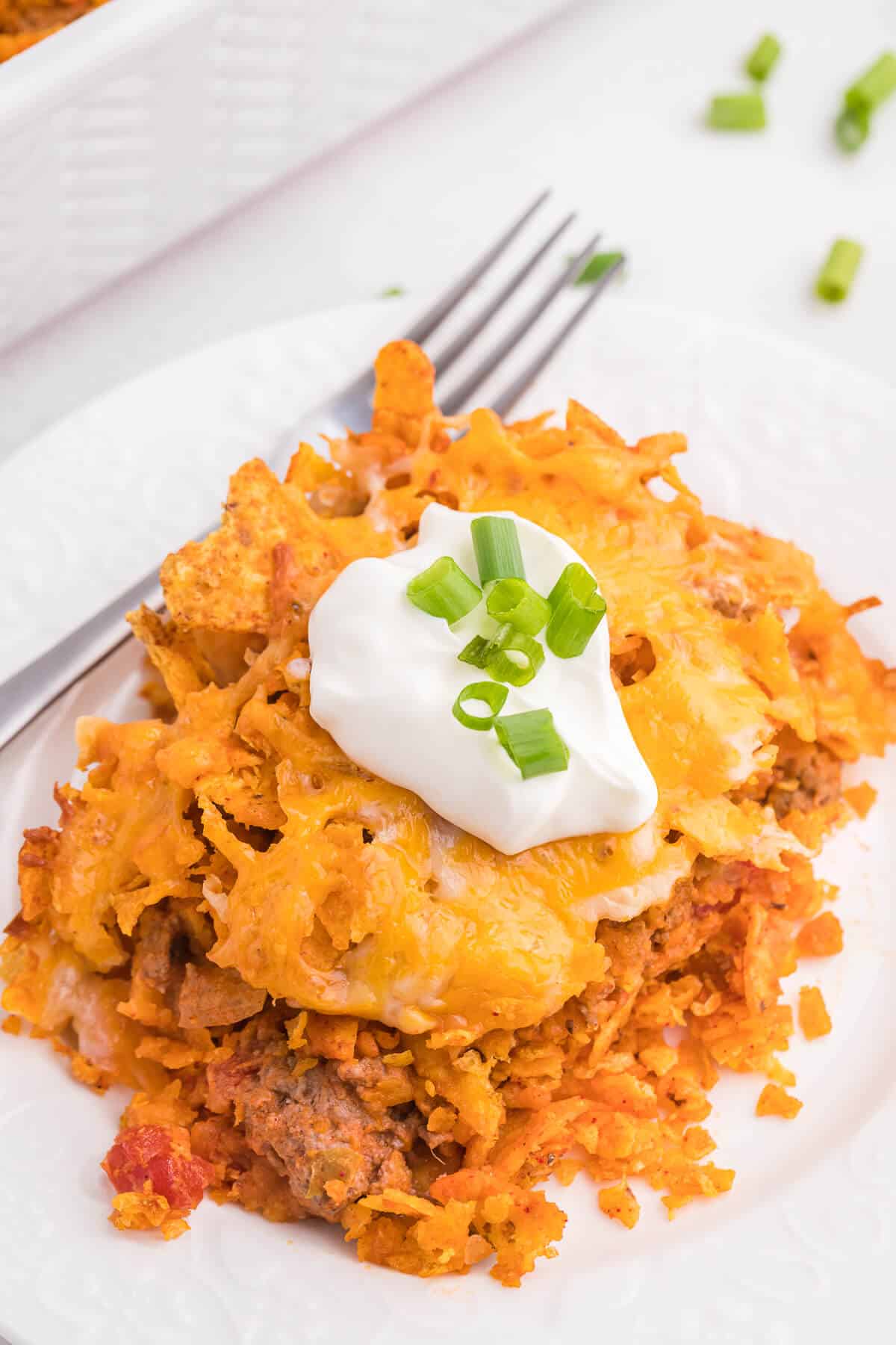 Doritos Casserole Recipe - Take Mexican night to a whole new level with this easy taco bake recipe. Made with ground beef, sour cream, spices and loads of cheese, it's zesty with hearty Tex Mex flavor. A yummy dinner recipe your family will love!