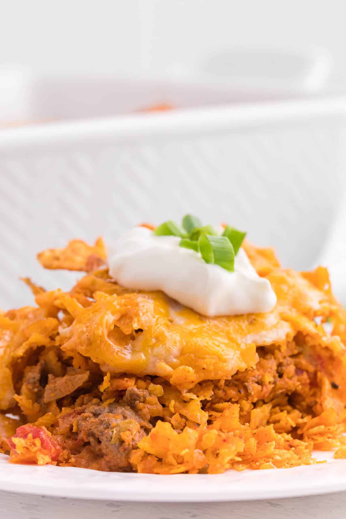 Doritos Casserole Recipe - Take Mexican night to a whole new level with this easy taco bake recipe. Made with ground beef, sour cream, spices and loads of cheese, it's zesty with hearty Tex Mex flavor. A yummy dinner recipe your family will love!