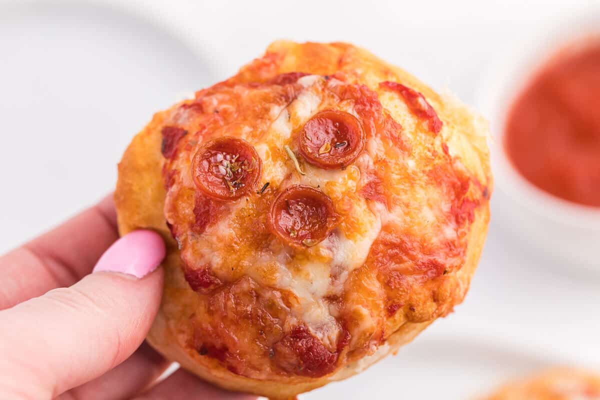 Air Fryer Pizza Buns - This simple recipe is perfect for snacking, an appetizer or for your kids' school lunch. Air fried to golden perfection, these savory buns are easy to make with refrigerated dough, pizza sauce, mozzarella cheese and pepperoni.