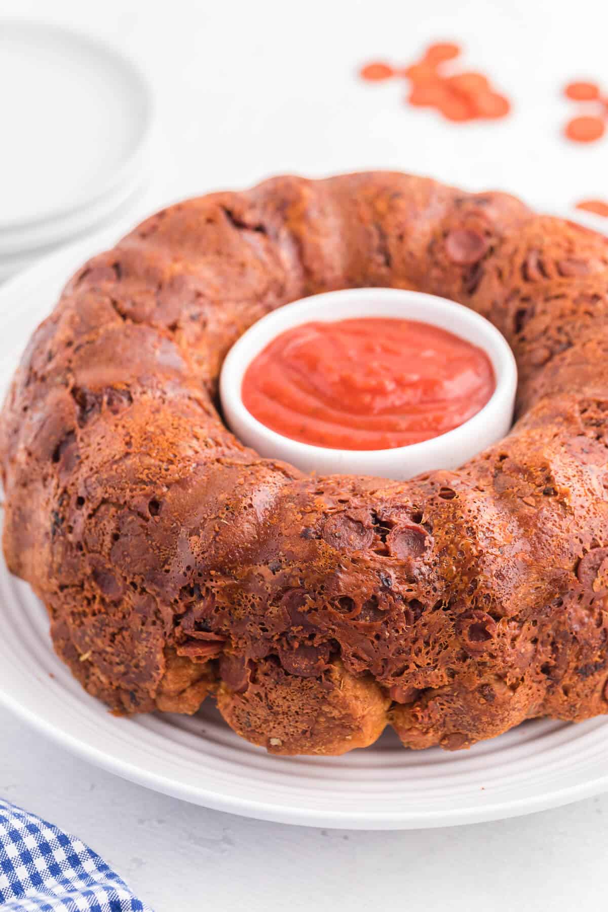 Pizza Monkey Bread Recipe - This pull apart game day recipe is simple to make in a bundt pan. Crescent roll dough, pepperoni and mozzarella cheese are combined to make the most delicious Italian-style appetizer. Serve with some pizza sauce for easy dipping!