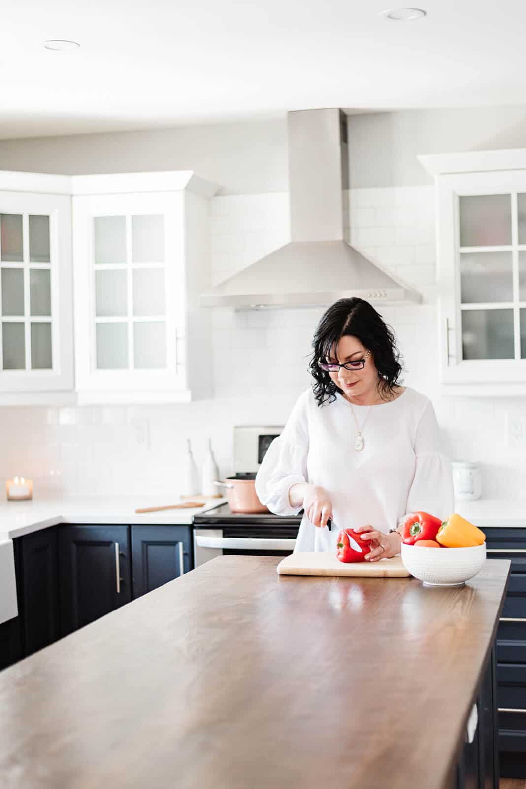 Food blogger Stacie Vaughan chopping a red pepper on a counter.