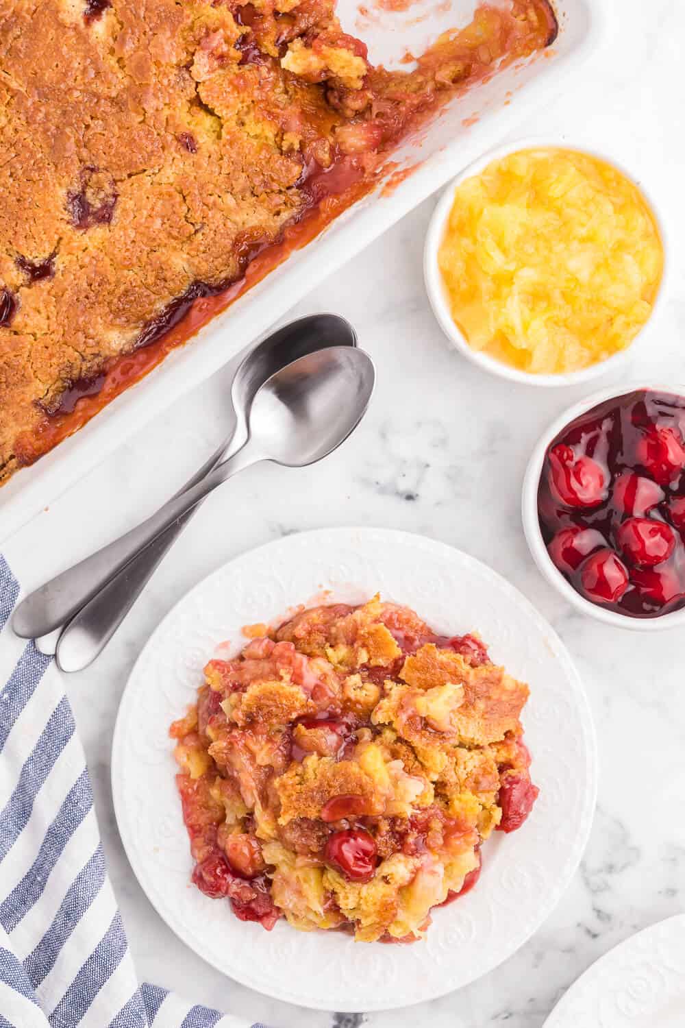 Cherry Pineapple Dump Cake Recipe - Made in 1 pan and only 4 ingredients in this quick and easy dessert recipe. Short prep time and no mixing! Perfect for potlucks and cookouts.