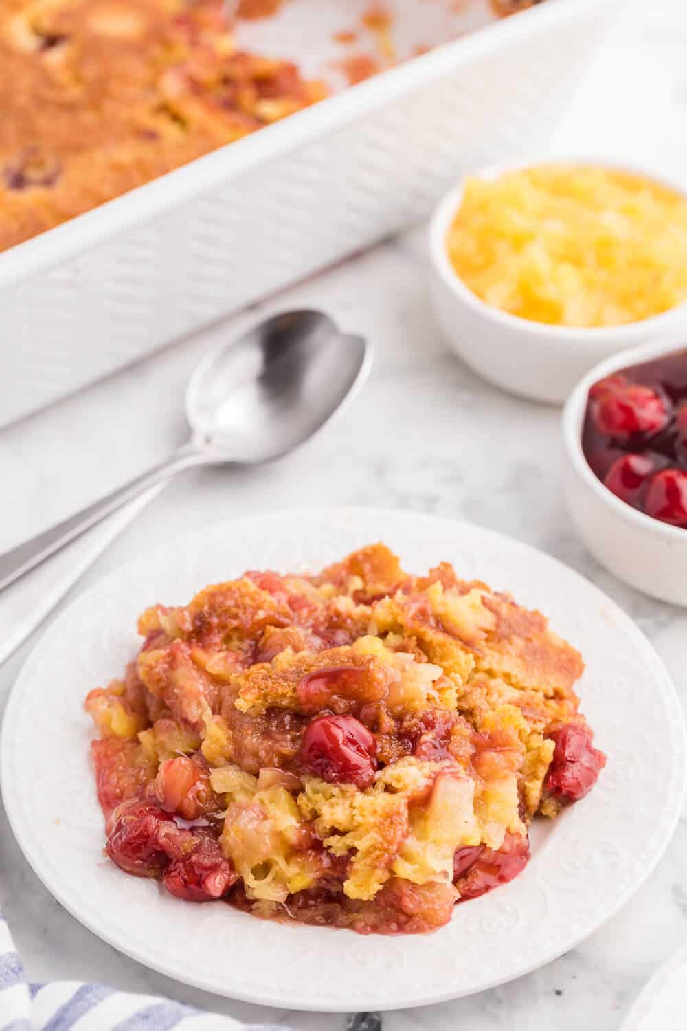 Cherry Pineapple Dump Cake Recipe - Made in 1 pan and only 4 ingredients in this quick and easy dessert recipe. Short prep time and no mixing! Perfect for potlucks and cookouts.