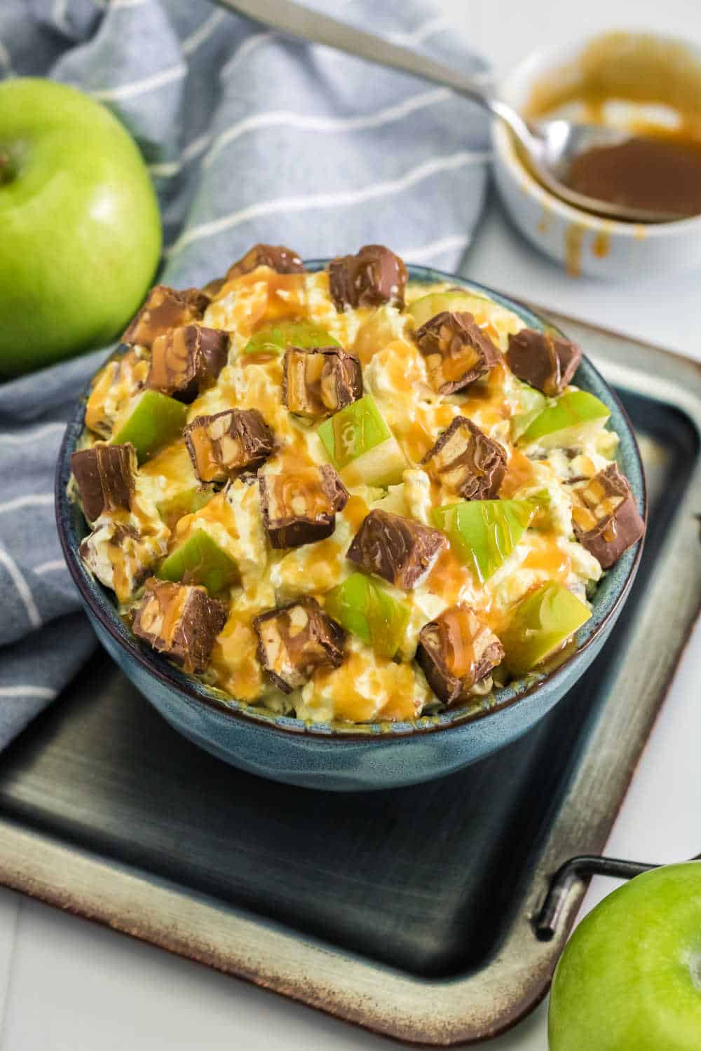 Snickers Salad Recipe - One of the best dessert salad recipes ever! This easy recipe is made with vanilla pudding, green apples, Cool Whip, caramel and loads of Snickers bars.