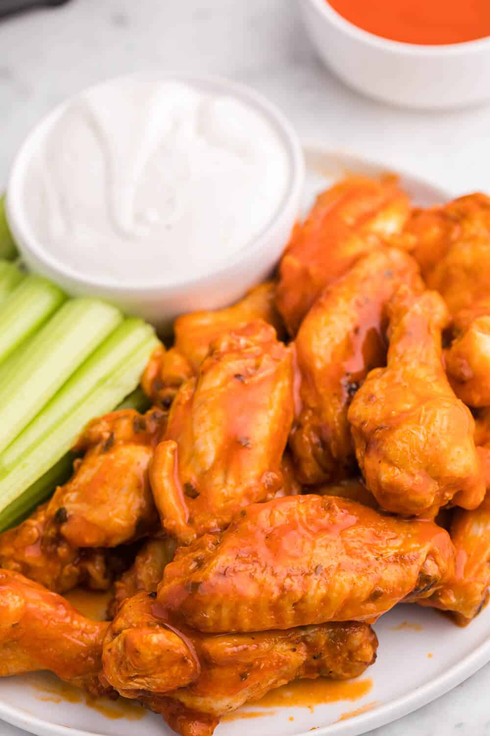 buffalo chicken wings on a plate with celery sticks and dip