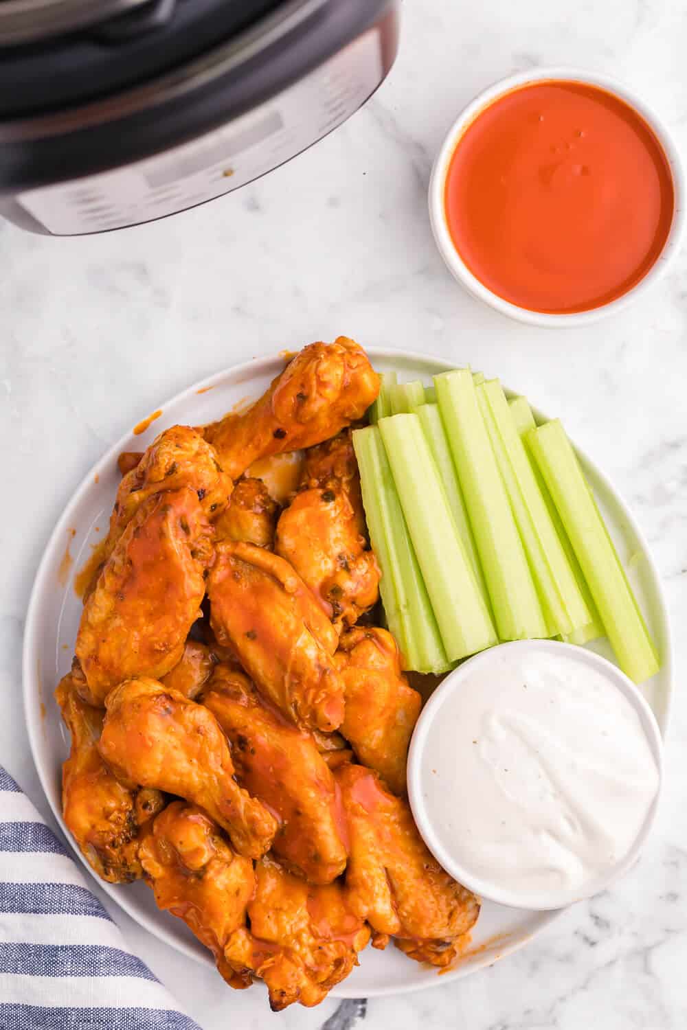 buffalo chicken wings on a plate with celery and ranch dip