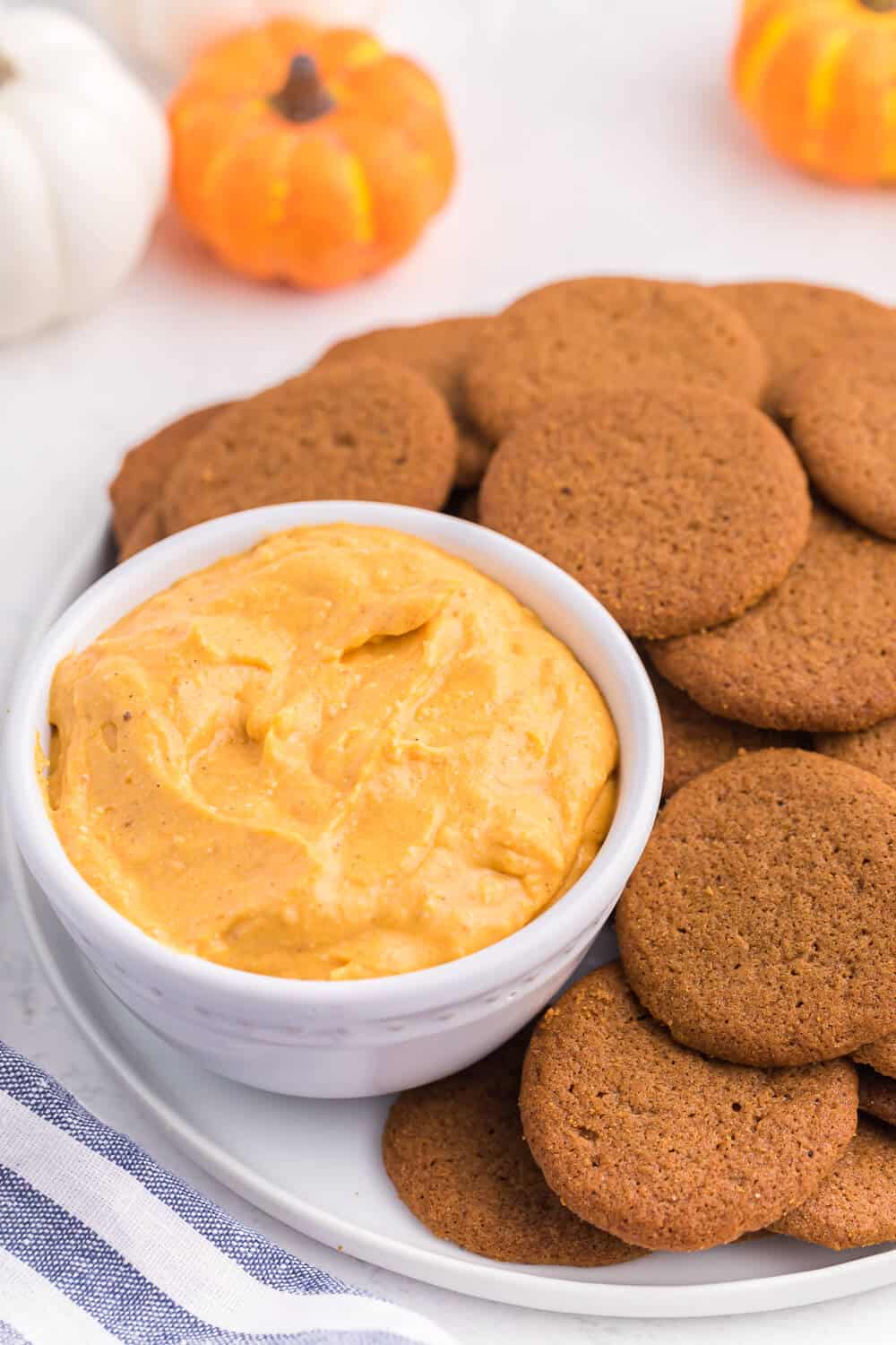 A plate of ginger cookies with pumpkin pie dip