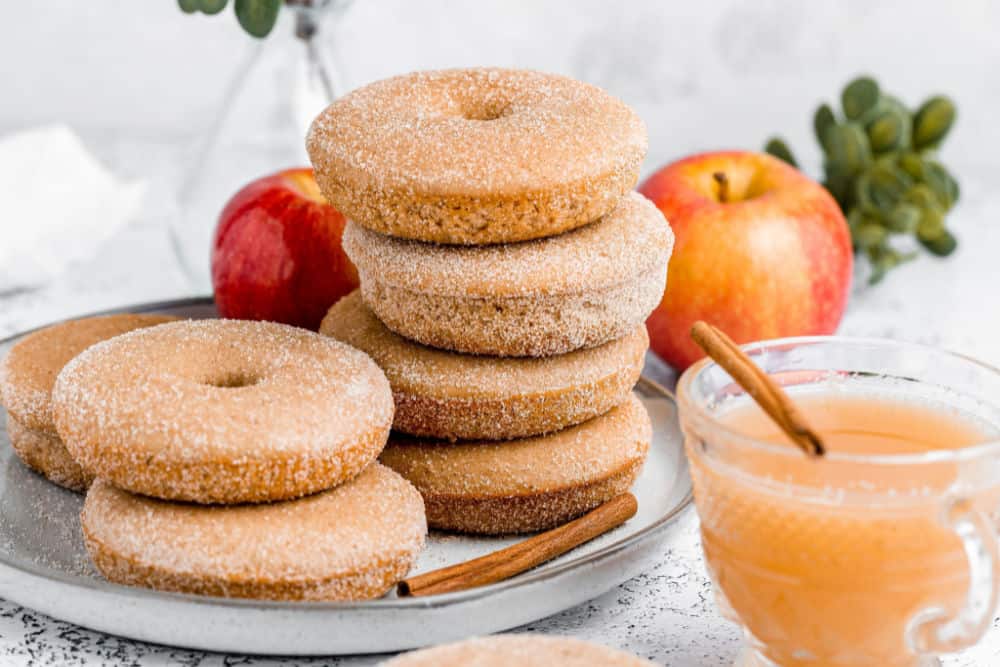 baked apple cider donuts stacked on a plate