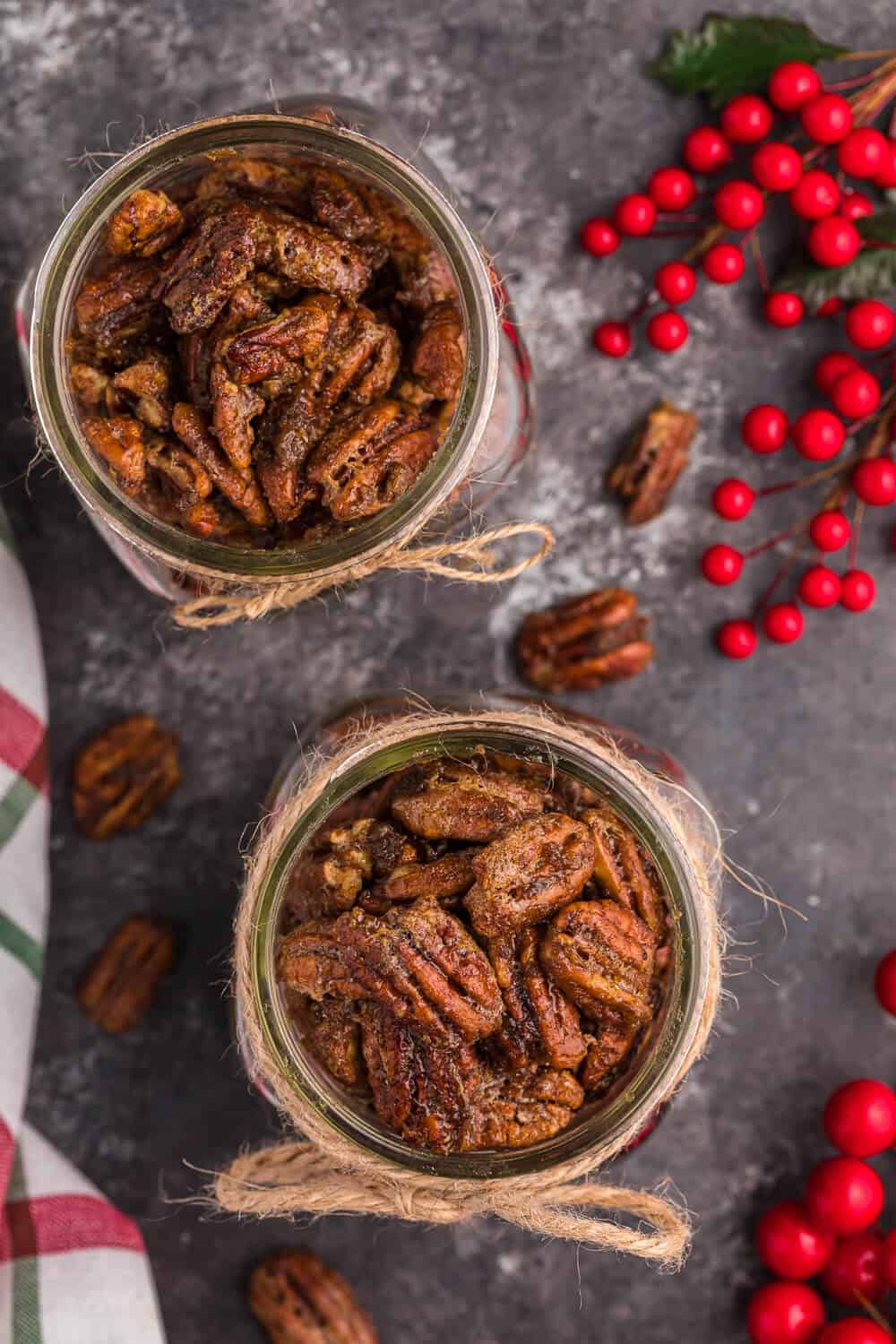 two jars of air fryer candied pecans with christmas decor