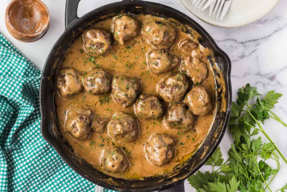 swedish meatballs with sauce in a cast iron skillet