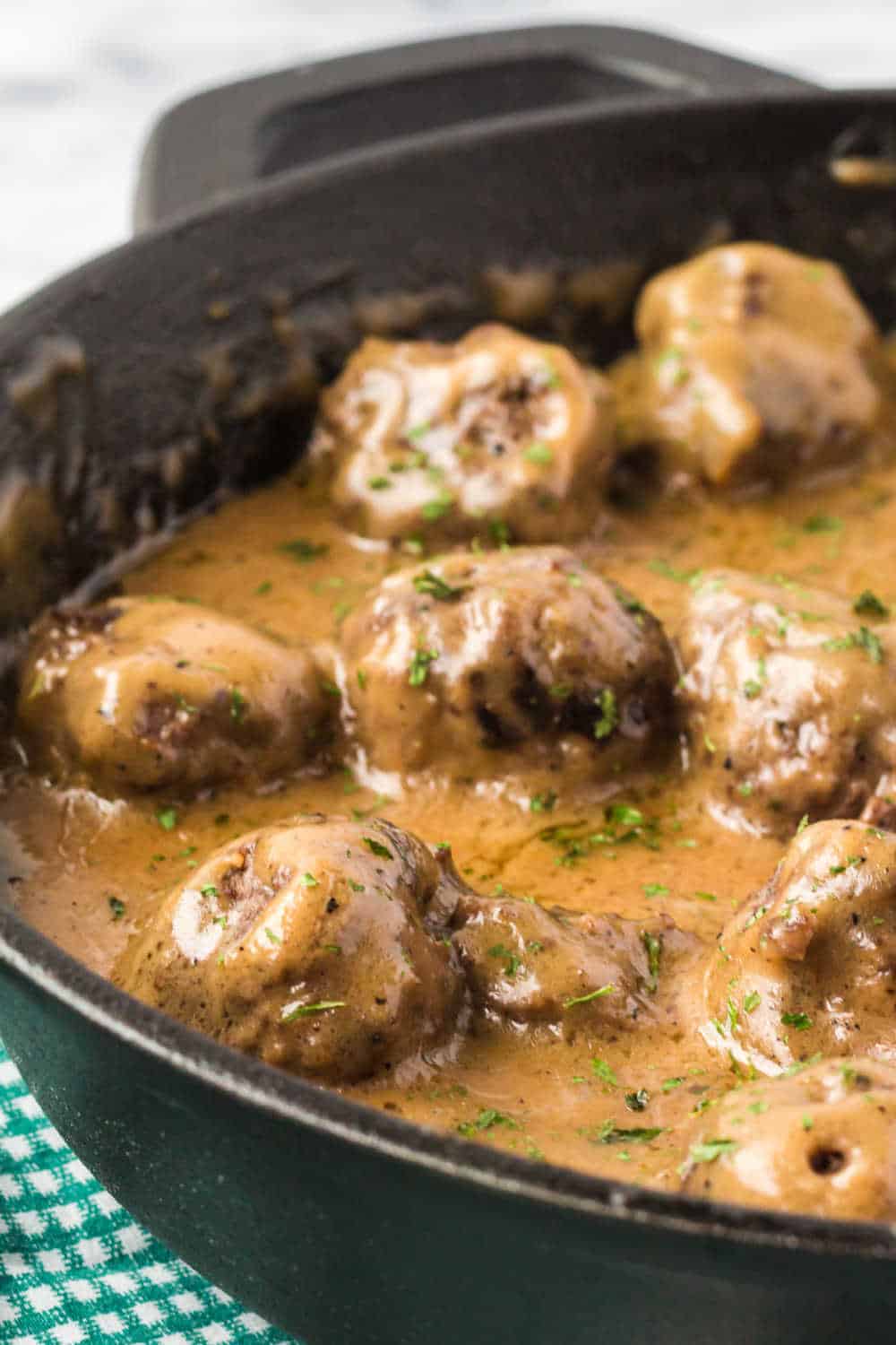 swedish meatballs with sauce in a cast iron skillet