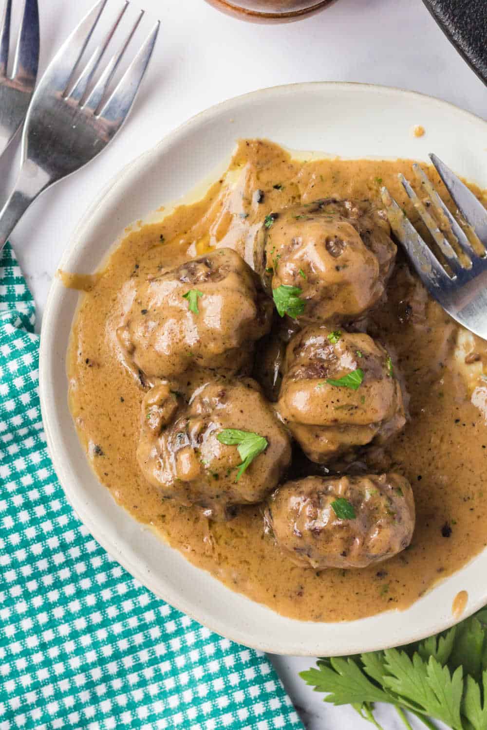 swedish meatballs on a white plate with loads of swedish meatball sauce