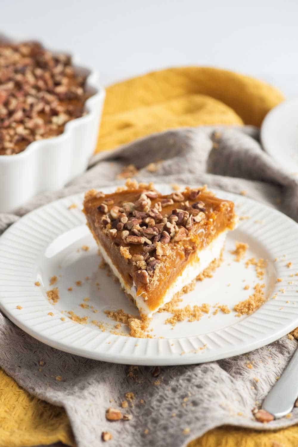 a slice of pumpkin pie cheesecake on a white plate