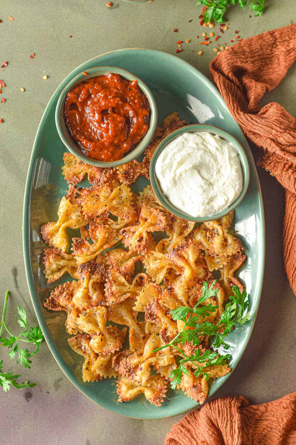 air fryer pasta chips on a green platter with dip