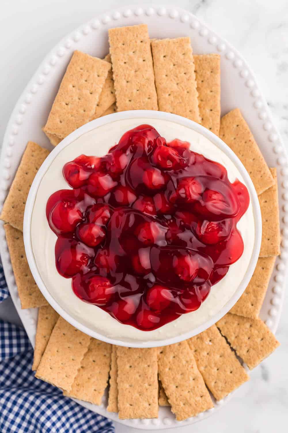cherry cheesecake dip on a platter with graham crackers