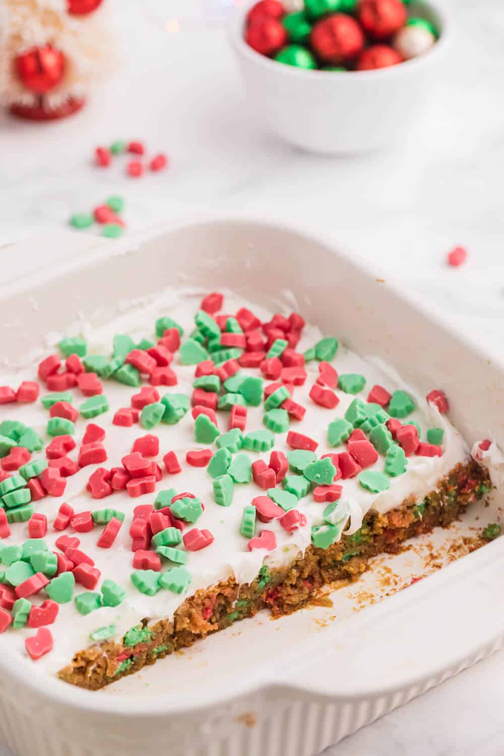 The recipe in a baking pan with some bars cut out of it.