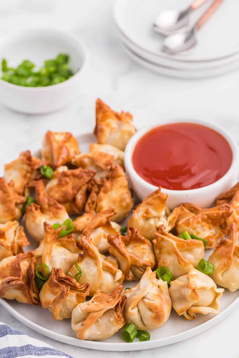 a plate of crab rangoon with sweet and sour sauce