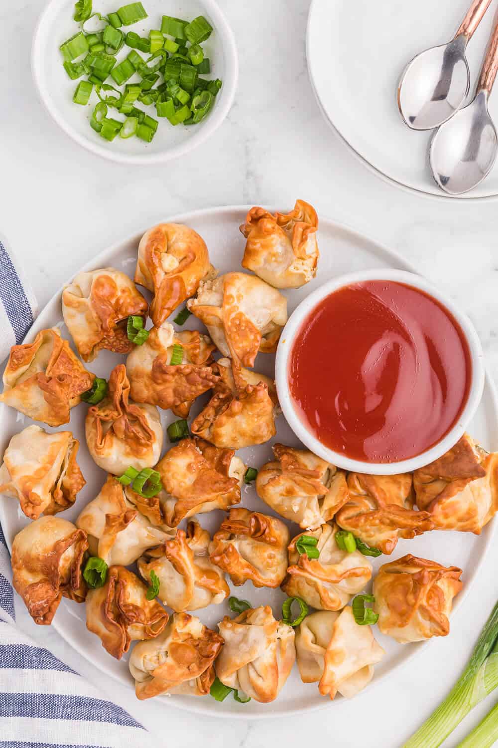 a plate of air fryer crab rangoon with sweet and sour sauce