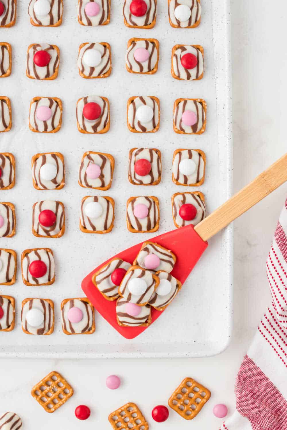 pretzel hugs on a baking sheet with a red spatula